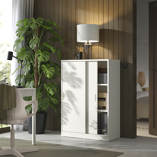 Escena moderna de oficina en casa con armario de almacenamiento TONSTAD blanco, puertas correderas, planta verde y escritorio.