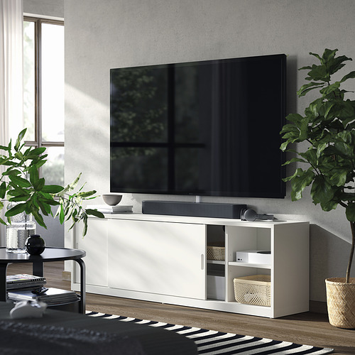 Sala de estar moderna con banco de televisión TONSTAD blanco, puertas correderas, estantes ajustables y plantas.