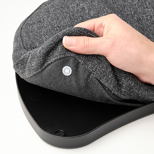 Cojín negro para portátil que se eleva a mano con funda de tela sobre una superficie plana.