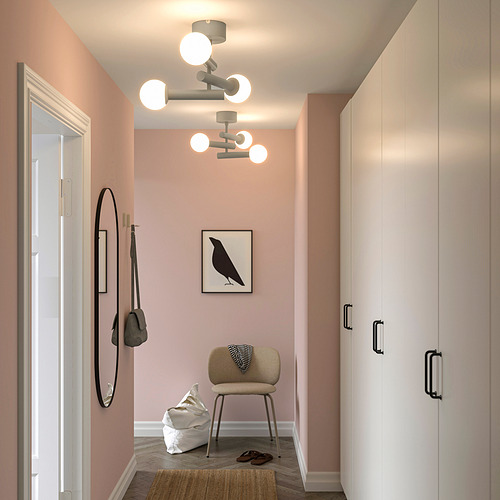 Pasillo moderno con lámpara de techo KRANBALK, paredes rosas, suelo de madera, espejo, gancho para bolsos, silla y armario. Iluminación sin deslumbramiento.