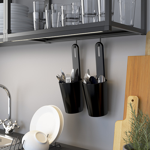 Cocina moderna con organización ENHET. Cubiertos y platos en vitrina. Fregadero y tabla de cortar visibles.