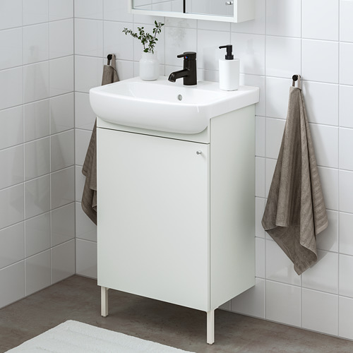 Moderno baño blanco: tocador de lavabo pequeño, grifo negro, toallas grises. Ahorra espacio con un diseño elegante.