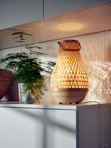 MISTERHULT lámpara de bambú con luz cálida, tejida a mano, mesa con planta.