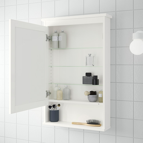 Mueble de pared HEMNES blanco con espejo, tres estantes de cristal. Sostiene artículos de tocador, maquillaje y cepillos.