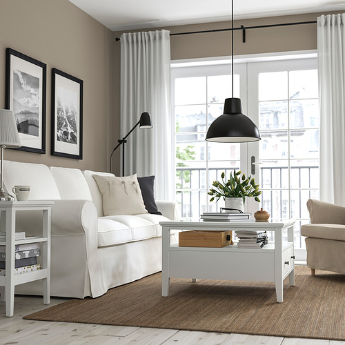 Sala de estar moderna con mesa de centro blanca y flores.