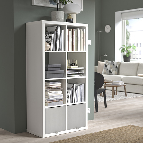 Caja de almacenamiento KOSINGEN blanca en la unidad kallax, que contiene libros y decoración, encaja perfectamente en la esquina, mezclándose con la decoración moderna de la habitación.