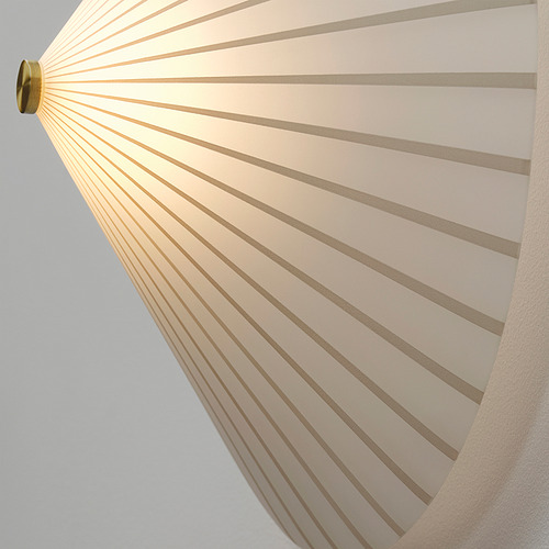 Una lámpara de pared moderna con una pantalla de vidrio opaco a rayas que emite una luz suave y difusa. Luminaria metálica de color dorado.