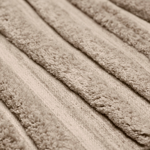 Alfombra de lana plegada en primer plano que muestra su textura suave y densa y su tono natural y terroso.
