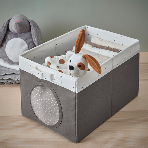 Una caja de almacenamiento de tela con asa y ventana de malla, que muestra juguetes de peluche y artículos para bebés en su interior.