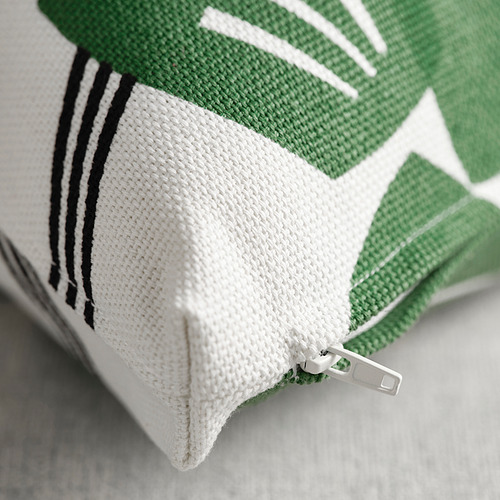 Detalle de detalle de cremallera en funda de cojín verde y blanco de alta calidad, que muestra costuras intrincadas y textura de tela.