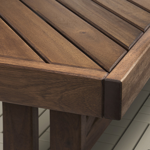 Primer plano de un robusto banco de madera para exteriores, que muestra un intrincado patrón de espiga y una veta duradera de madera de acacia.