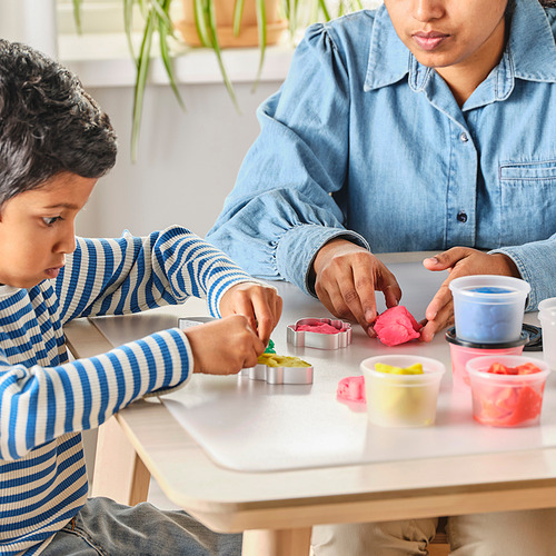 Dos personas jugando con masa de colores para modelar y cortadores de galletas.