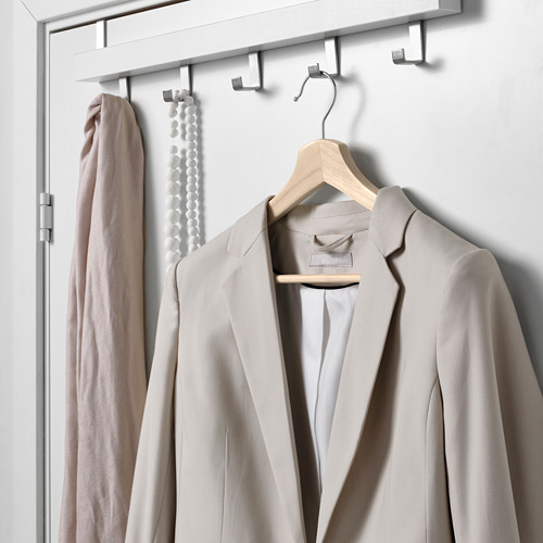 Percha de madera con chaqueta beige y bufanda sobre ganchos.