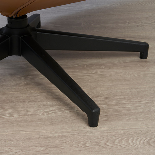 Pata de silla de metal negro con fondo de suelo de madera.