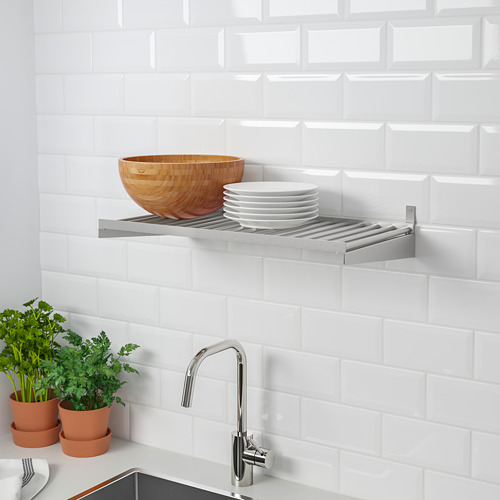Cocina moderna con estante KUNGSFORS que sostiene tazón y platos, grifo cromado y ollas de hierbas.