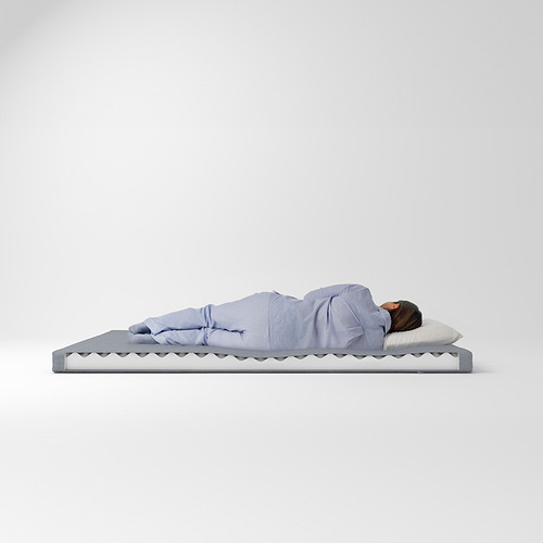 Persona durmiendo en un colchón de espuma ÅGOTNES, azul claro, rectangular, diseño sencillo.