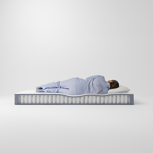 Una persona duerme en un colchón VESTERÖY azul que se muestra desde el lateral, resaltando sus firmes capas de soporte y comodidad con muelles ensacados.