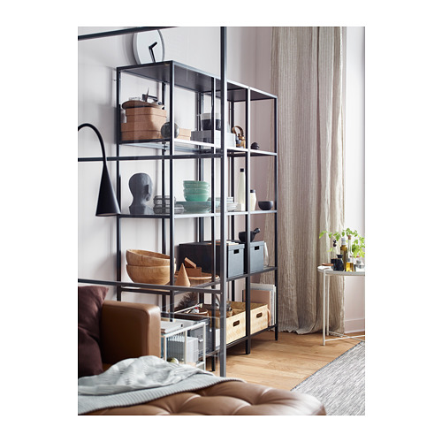 Salón moderno con estantería VITTSJÖ, sofá, ventana.