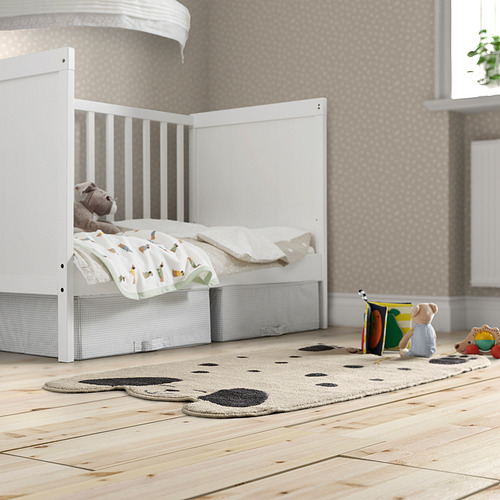 Habitación para niños con alfombra gris DRÖMSLOTT, cama para niños pequeños, juguetes y una ventana grande.