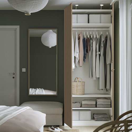 Moderno armario PAX con puerta abierta, ropa y cajas de almacenamiento.