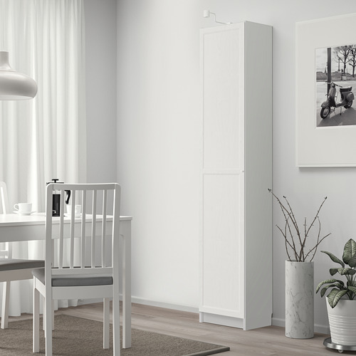 Habitación moderna con estantería BILLY, comedor y plantas. Estantería alta al lado de la foto del scooter.