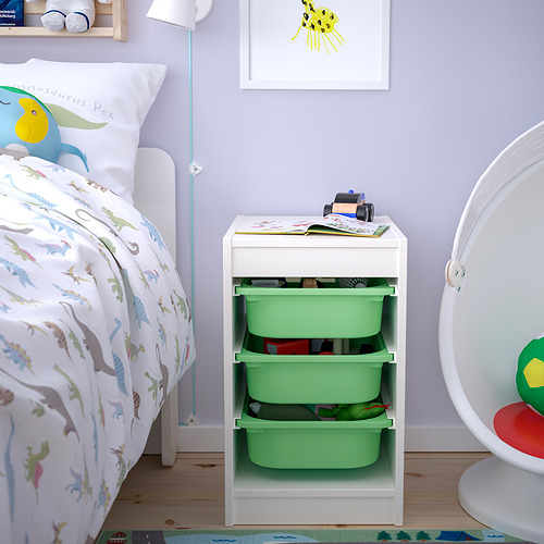 Childs room with TROFAST storage. White frame, green plastic boxes. Next to a bed and above a rug.