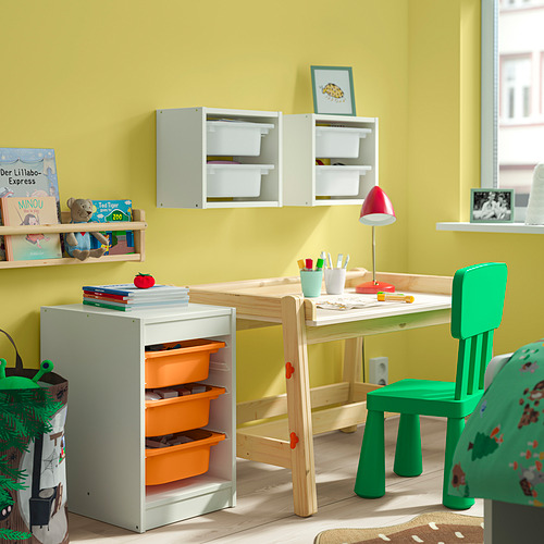 Habitación para niños con almacenamiento blanco TROFAST, papeleras naranjas, silla verde. Espacio luminoso y organizado.