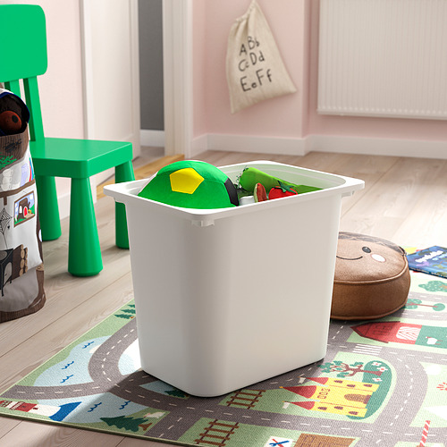 Sala de juegos para niños con contenedor de almacenamiento lleno de juguetes en una alfombra de colores, silla verde, juguete de peluche.