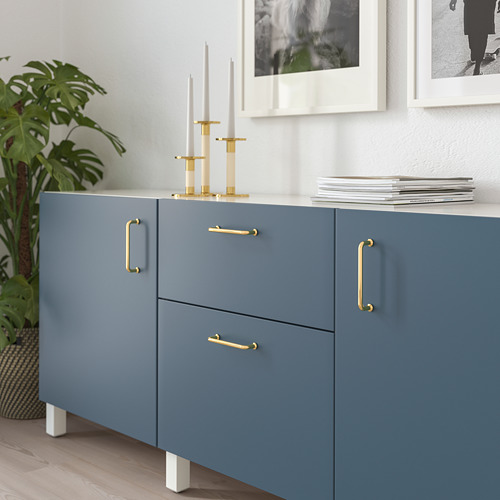 Mueble azul con manijas doradas, decorado con candelabros y revistas; Adecuado para una casa moderna.