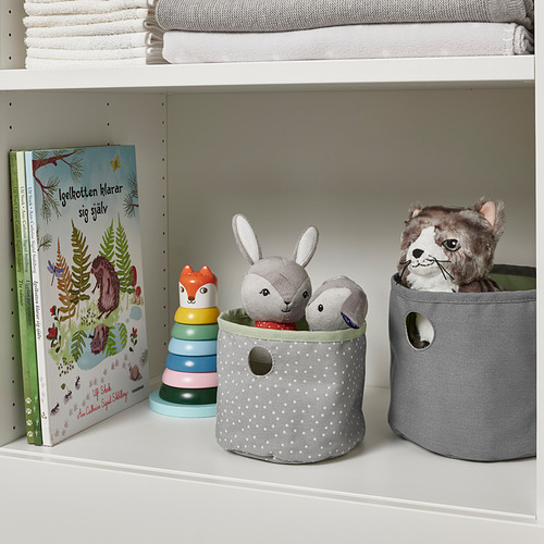 Estantería infantil con cubos de almacenamiento: libros, peluches y contenedores de tela.