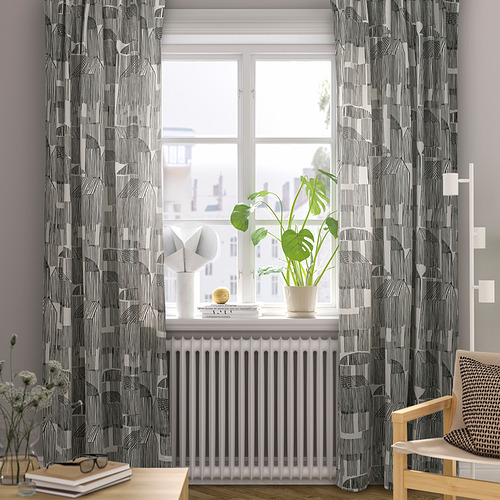 Cortinas grises, silla, planta y decoración junto a la ventana.