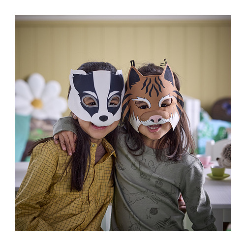 Dos niños con máscaras de tejón y lince sonríen en una habitación acogedora.