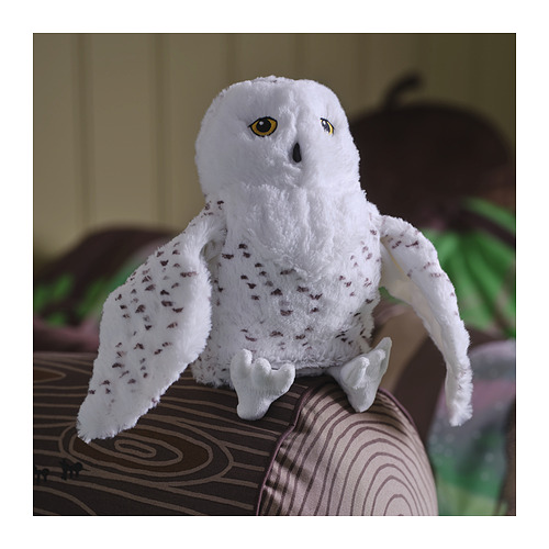 El suave juguete de búho blanco SKOGSDUVA se sienta sobre un cojín. Ojos grandes y redondos, pequeñas manchas marrones. Tamaño similar al de una mano.