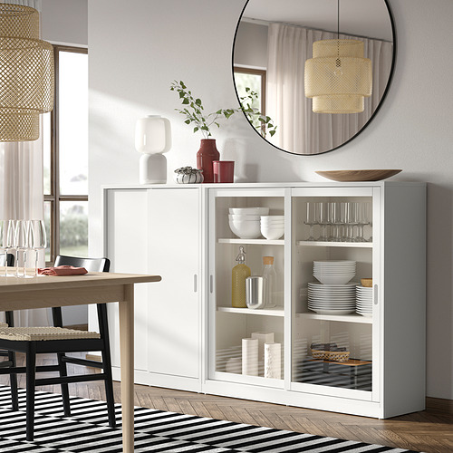 Modern dining room with TONSTAD sideboard, vases, mirror, and pendant lamp.