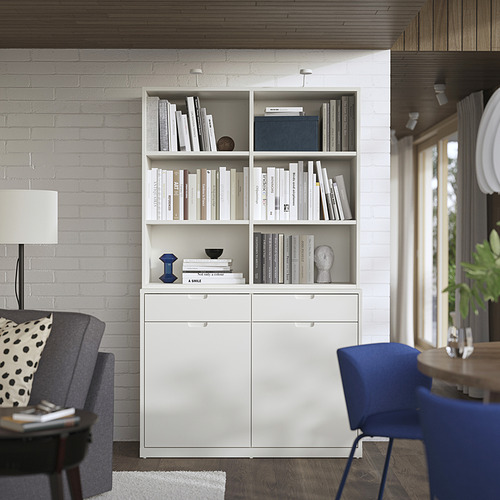 Moderna librería y aparador blanco TONSTAD en salón con silla gris, lámpara y silla azul.