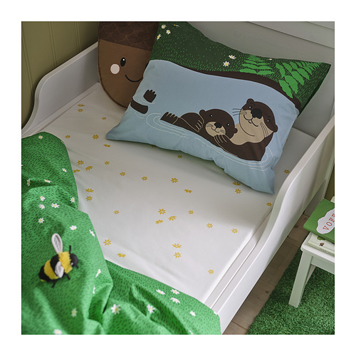 Cama de oso azul con manta y taburete verdes, juguete de peluche, estampado de árbol.