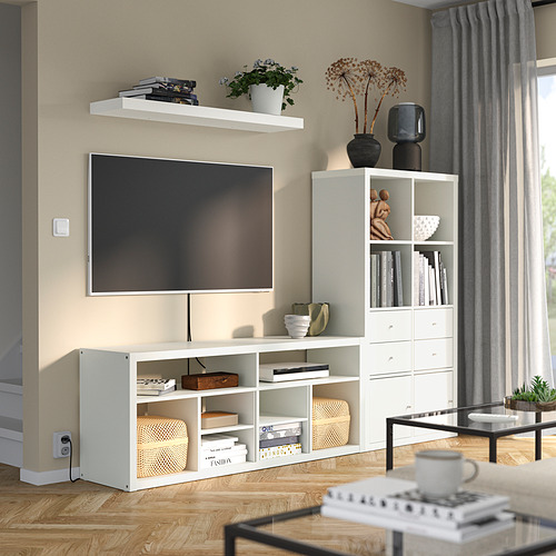 Sala de estar moderna con unidad de TV KALLAX y estantes, libros, plantas y un acogedor rincón de lectura.
