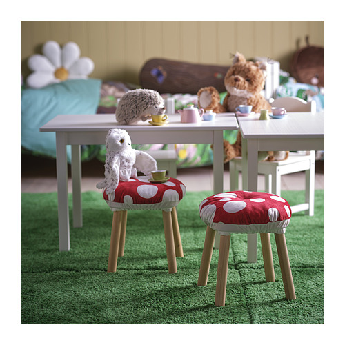 Cojines de lunares sobre taburetes con peluches y tazas de té, perfectos para que los niños jueguen en un entorno forestal caprichoso.