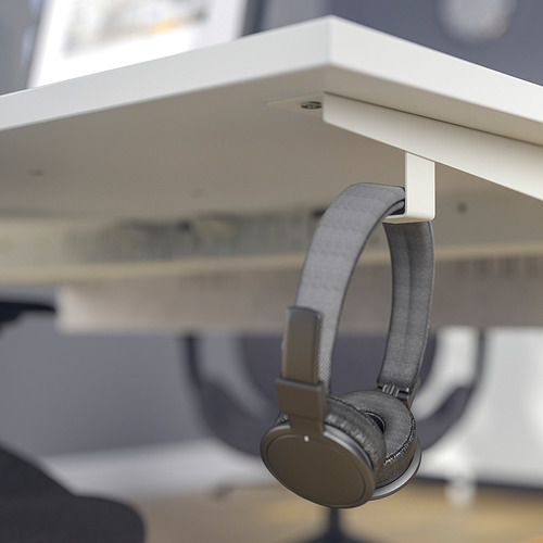 Los auriculares cuelgan del gancho de escritorio MITTZON, mostrando su característica organizativa.