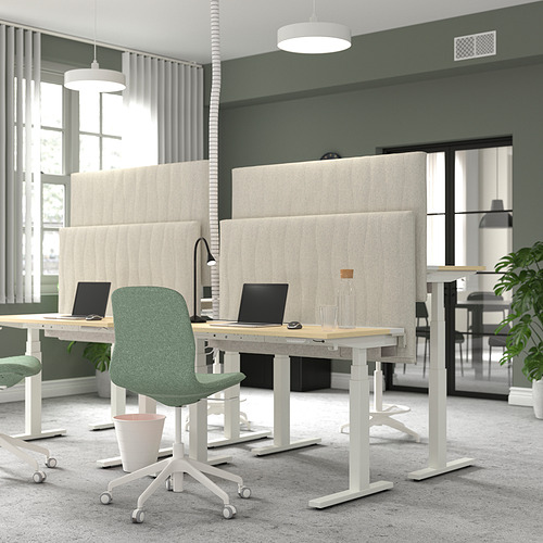 Espacio de oficinas con pantallas acústicas MITTZON en color beige. Sillas verdes sobre escritorios blancos con computadoras portátiles. Grandes ventanales con cortinas.