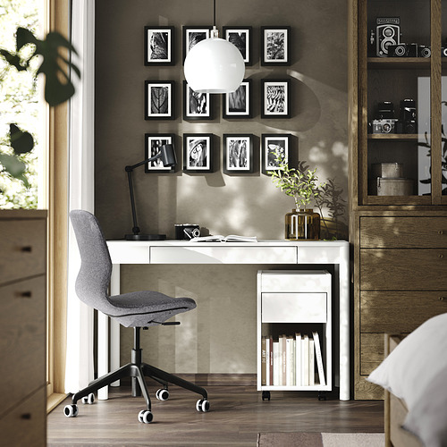 Moderna oficina en casa con escritorio blanco TONSTAD, silla gris, arte de pared y armario de madera.