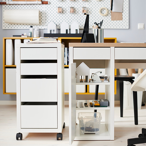 Moderno escritorio blanco con cajones y estantes, con suministros cuidadosamente dispuestos y una decoración en forma de casa.