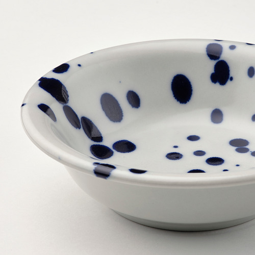 Cuenco blanco con manchas azules, bordes lisos.