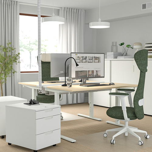 Moderna oficina en casa con escritorio MITTZON, silla verde, pantalla grande y accesorios. Habitación luminosa con grandes ventanales.