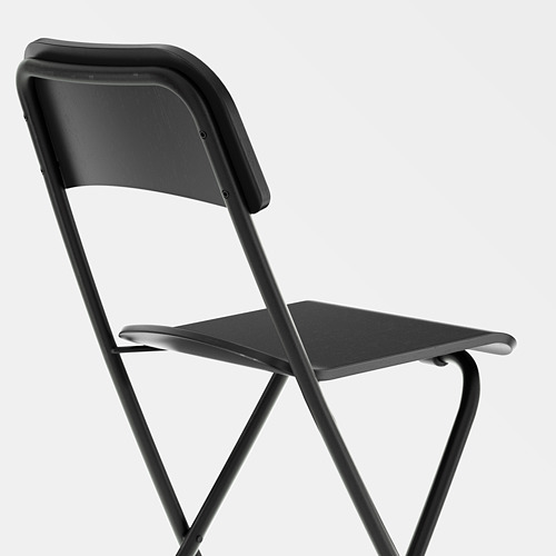 Taburete plegable negro con estructura metálica y asiento de madera. Diseño robusto, fácil de plegar.