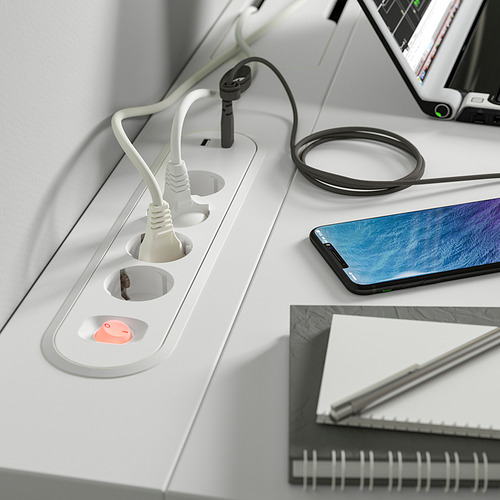 Escritorio blanco con tomas de corriente incorporadas, un teléfono inteligente, una computadora portátil y auriculares. Bandeja de gestión de cables preinstalada.