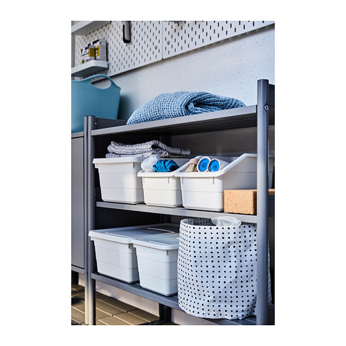 Una estantería de metal gris con contenedores de almacenamiento blancos y textiles doblados.