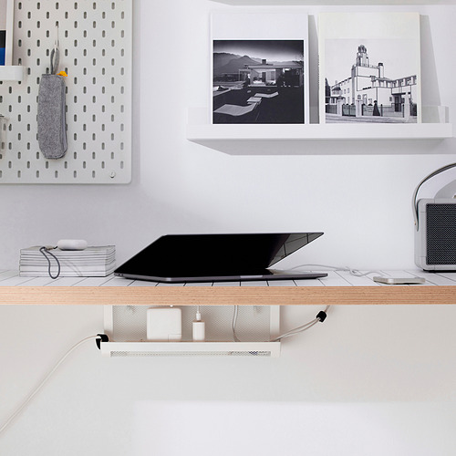 Espacio de trabajo minimalista en blanco: ordenador portátil, altavoces, accesorios en estanterías; La pequeña bandeja FÖRSÄSONG gestiona los cables de forma ordenada.