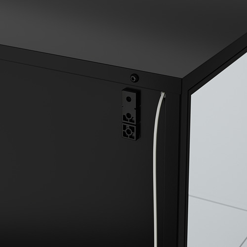 Mueble negro con iluminación integrada. Gestión de cables visible en el lateral.
