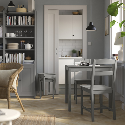 Moderno juego de comedor gris con mesa y sillas de madera, cerca de la entrada de la cocina.